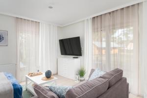 a living room with a couch and a flat screen tv at Apartament Baltic Residence Nr 5 in Pobierowo