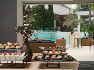 a table topped with trays of muffins and desserts at Galaxy Iraklio Hotel in Heraklio