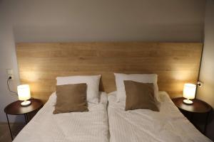 a bedroom with a bed with two lamps on it at Griboedov Apartment in Tbilisi City