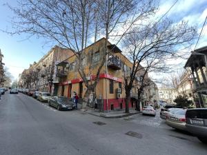 a building on the side of a street with parked cars at Griboedov Apartment in Tbilisi City