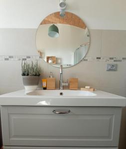 a bathroom with a white sink and a mirror at Casale Monte Valestra in Bebbio