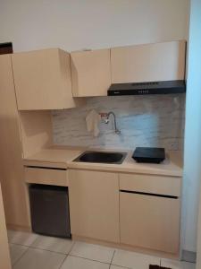 a kitchen with white cabinets and a sink in it at Apartemen MAJ at Ecohome Citra Raya in Nalagati