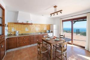 a kitchen with a table with chairs and a view of the ocean at Villa Amanecer by Villa Plus in Cumbre del Sol