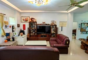 a living room with a couch and a television at Taitung XD B&B in Taitung City