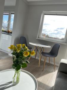 una sala de estar con una mesa y flores amarillas en un jarrón en LUXURY WHITE APARTMENT by Marta, en Radom