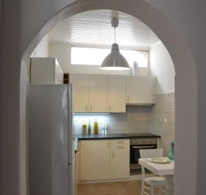 an archway in a kitchen with a stainless steel refrigerator at Mythos Residence in Rethymno