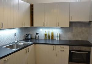 a kitchen with white cabinets and a sink at Mythos Residence in Rethymno