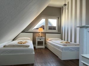 2 Betten in einem Zimmer mit Fenster in der Unterkunft Muck in Westerland