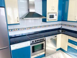 cocina azul con fogones y fregadero en Casa de Anmar casa independiente con jardín, Ajo, en Ajo