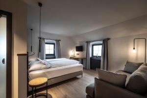 una camera da letto con un letto e un divano di Ansitz Fonteklaus a Chiusa