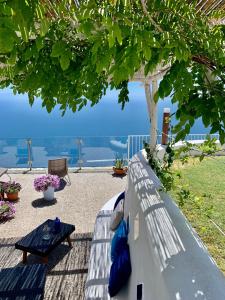 um banco com uma mesa e vista para o oceano em La casa del '600 Holiday House Amalfi Coast em Amalfi
