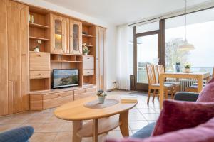 een woonkamer met een bank, een tv en een tafel bij Haus Fernsicht Wohnung 13 in Kellenhusen