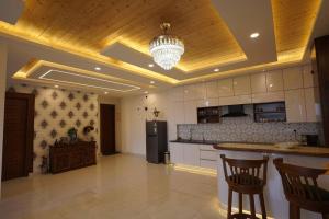 a large kitchen with a chandelier and a island in a room at The Cerro Rico - 3 BHK Modern Villa in Kasauli +45 photos
