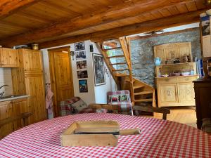 a kitchen with a table with a red and white checkered table cloth at Casa Ornella - Baita Pra Sec in Montita