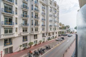 un grand bâtiment blanc avec des motos garées devant lui dans l'établissement Le Grain d'or, à Cannes