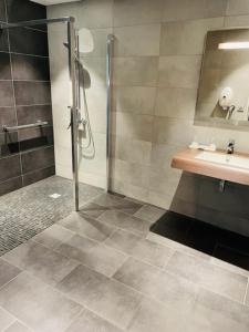 uma casa de banho com um chuveiro e um lavatório. em Hotel de l'Europe em Dieppe
