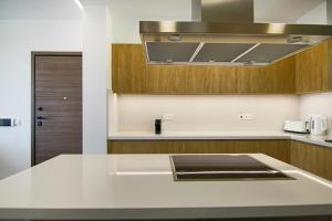 uma cozinha com um balcão branco e um lavatório em Phaedrus Living: City View Anna Residence 102 em Limassol