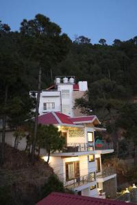 a large white building on a hill with trees at The Cerro Rico - 3-Bedroom Modern Villa in Kasauli