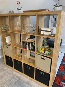 a wooden book shelf with a bowl of fruit in it at Ferienwohnung Sunny - Moderne Ferienwohnung im Grünen in Saarbrücken-West in Saarbrücken