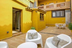 a patio with two white chairs and a table at Apartamento en el centro in Begur
