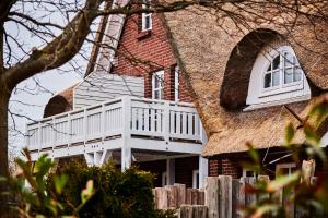 a house with a white porch and a roof at GRONERS Ahrenshoop in Ahrenshoop