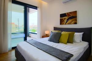 - une chambre dotée d'un grand lit avec des oreillers jaunes et bleus dans l'établissement Phaedrus Living: Sea View Anna Residence 201, à Limassol