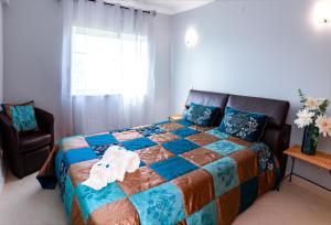 een slaapkamer met een bed, een stoel en een raam bij Tatiana 1 bedroom apartment in Albufeira