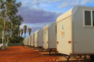 una fila de remolques blancos estacionados en una fila en Meekatharra Accommodation Centre, en Meekatharra