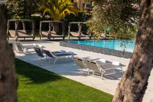 a group of tables and chairs next to a swimming pool at Pietra Bianca Hotel in Numana