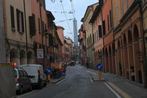 an empty city street with cars parked on the side at Affittacamere V Torre V Nigrisoli a Porta San Vitale in Bologna