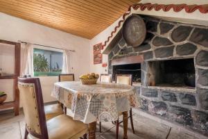 a dining room with a table and a stone fireplace at Casa rural Teno Alto in Buenavista del Norte