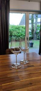 two empty wine glasses sitting on a wooden table at Apartment 1 in Leverkusen
