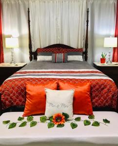 ein Schlafzimmer mit einem Bett mit orangefarbenen Kissen in der Unterkunft Villa Altiery Puerto Rico in Caguas
