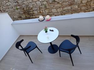 un tavolo con due sedie e un tavolo con le scarpe sopra di Vila Vasiliu Ksamil a Ksamil