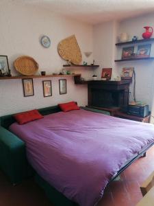 リヴィゾンドリにあるResidence La baitaの棚付きの客室内の大きな紫色のベッド