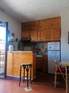 a kitchen with wooden cabinets and a refrigerator at Residence La baita in Rivisondoli