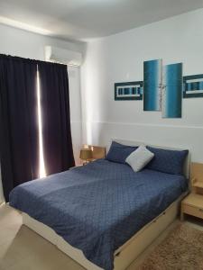 a bedroom with a bed with a blue comforter at Modern Apartment in Swieqi Malta in St. Julianʼs
