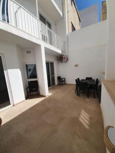a patio with a table and chairs in a building at Modern Apartment in Swieqi Malta in St. Julianʼs