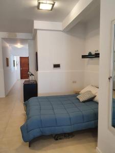a bedroom with a blue bed in a room at Modern Apartment in Swieqi Malta in St. Julianʼs
