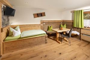 a bedroom with a bed with a desk and a table at Gästehaus Kaltbachhäusl Garni in Ramsau