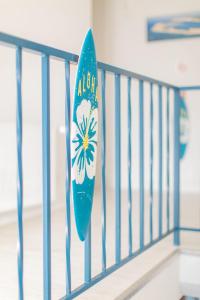 a blue railing with a surfboard on it at Hôtel Land'Azur in Mimizan-Plage
