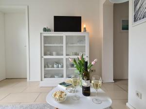 a living room with a table with wine glasses and a tv at Neu eingerichtetes Apartment #1 mit WLAN !Sauna & Hot Tub zubuchbar! in Senftenberg