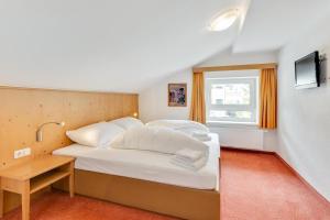 a bedroom with a large white bed and a window at Chalet Martin in Sankt Anton am Arlberg