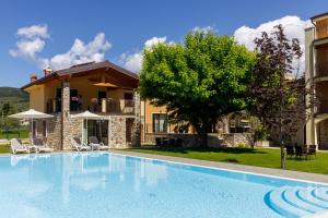 a large swimming pool in front of a house at Residence Rustico in Garda