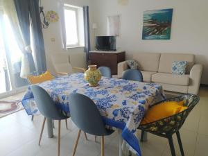 a dining room table with chairs and a vase on it at Blue Sky House in Taormina