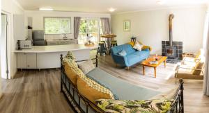 a living room with a blue couch and a kitchen at Further Beyond in Hogsback