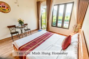 a bedroom with a bed and a table and a window at Tam Coc Minh Hung Homestay in Ninh Binh