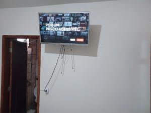 TV de pantalla plana colgada en la pared en Atlantic Hotel - Campo Grande, en Campo Grande