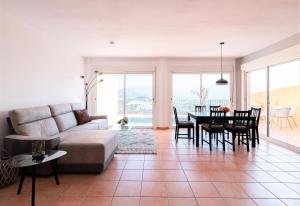 ein Wohnzimmer mit einem Sofa und einem Tisch in der Unterkunft Casa Linda Vista Altea Costa Blanca in Callosa d'en Sarrià
