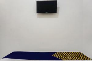 een kamer met een tv aan een witte muur bij OYO 90928 Wisma Asri Putra Syariah in Bogor